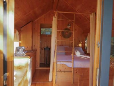 Cabane en bois cosy en Aquitaine, avec lit douillet et cuisine intégrée.