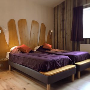 Chambre dhôtes moderne avec lits jumeaux et décor en bois chaleureux.