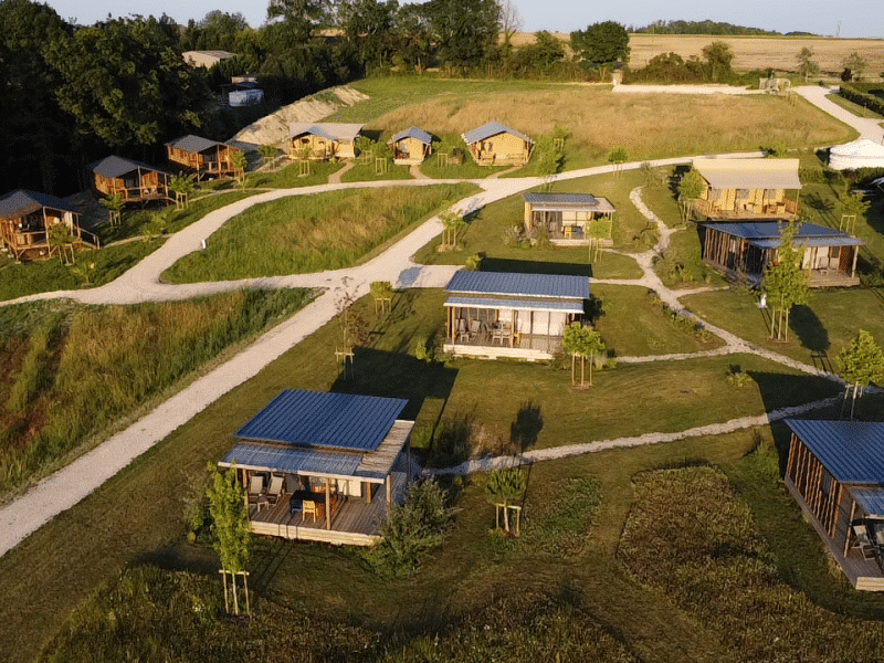 Cabanes en bois entourées de verdure, offrant un cadre paisible et naturel.