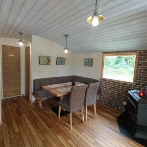 Hébergement insolite à Limousin : intérieur chaleureux avec parquet en bois et coin repas.