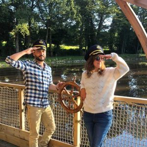 Hébergement insolite à Limousin : bateau sur leau avec couples en tenue de capitaine.