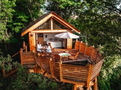 Cabane dans les arbres à Hauts-de-France, avec terrasse en bois et vue sur la nature.