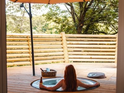 Hébergement insolite en Hauts-de-France : jacuzzi sur terrasse en bois, ambiance relaxante.