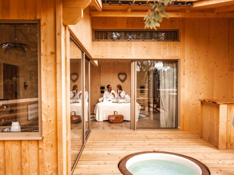 Cabane en bois avec jacuzzi, offrant un cadre romantique et chaleureux.