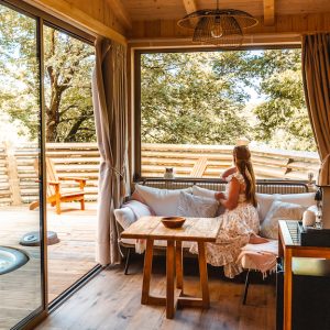 Hébergement insolite en bois avec vue sur la nature et terrasse ensoleillée.