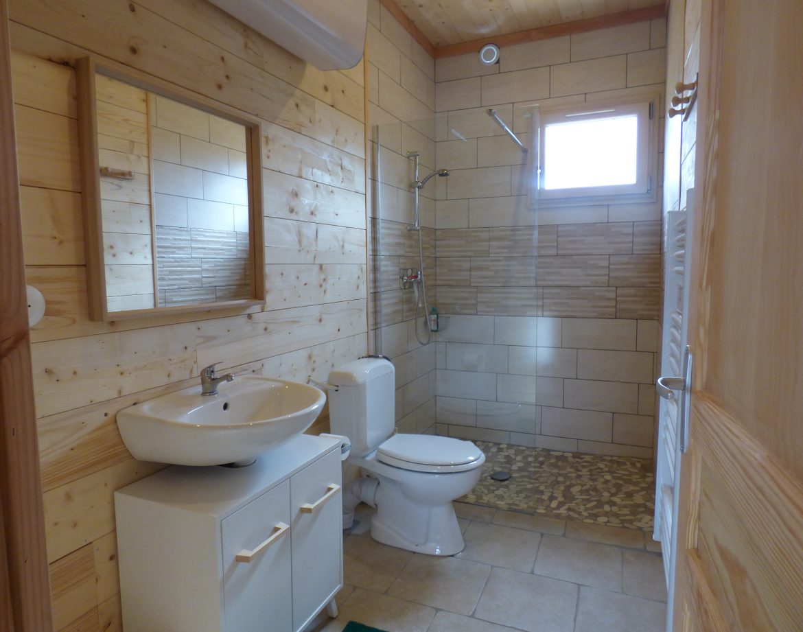 Salle de bain moderne en bois dans un hébergement insolite en Auvergne.