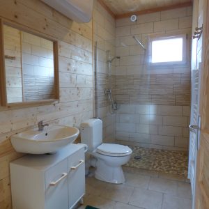 Salle de bain moderne en bois dans un hébergement insolite en Auvergne.