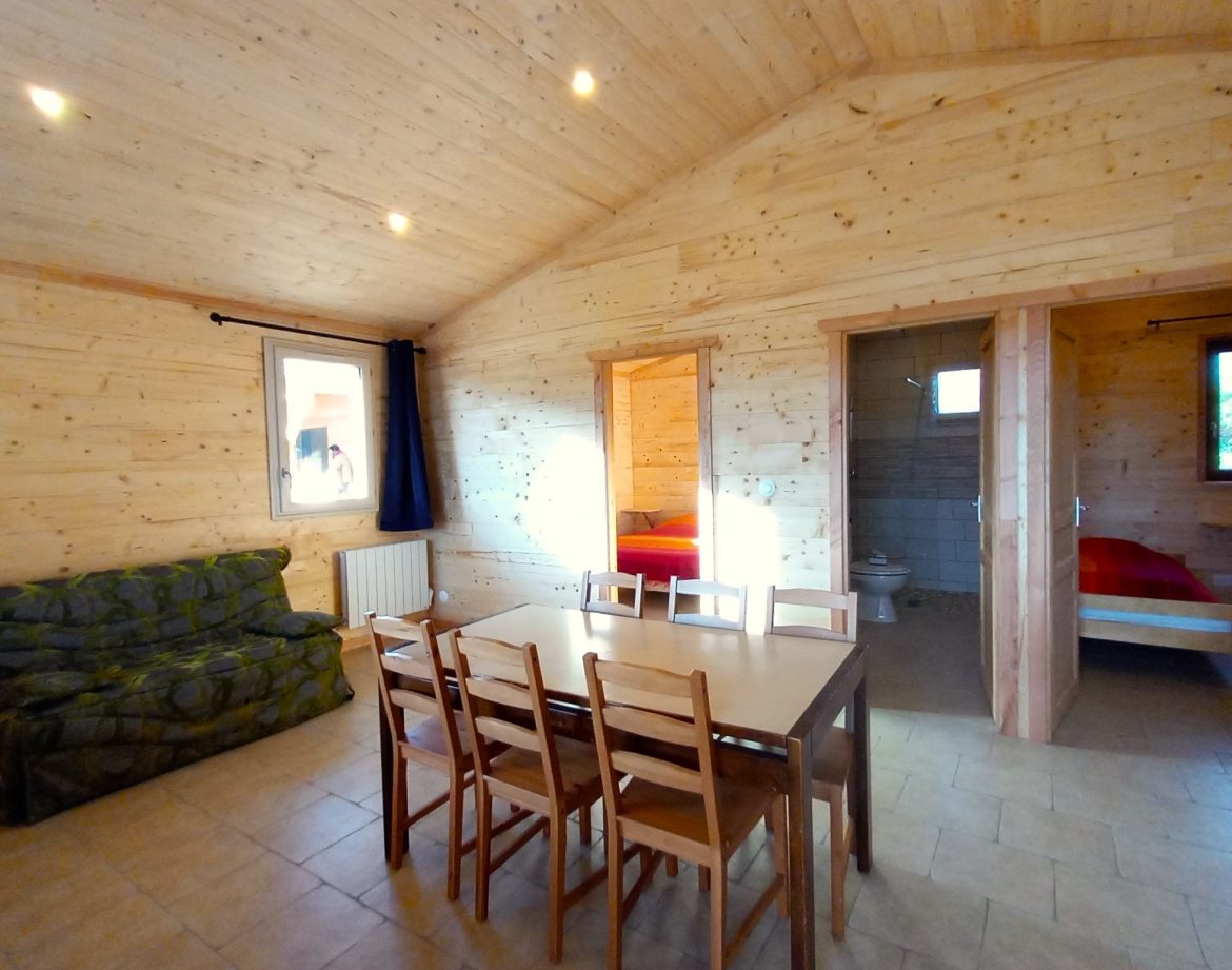 Chalet en bois spacieux avec salle à manger et vue sur la nature en Auvergne.