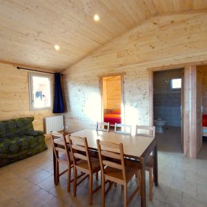 Chalet en bois spacieux avec salle à manger et vue sur la nature en Auvergne.
