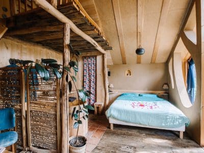 Hébergement insolite en Bretagne : chambre chaleureuse avec lit douillet et décoration bois.