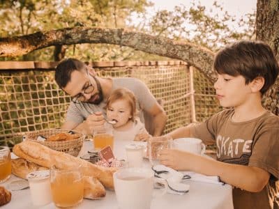 Séjour en cabane dans les arbres, petit-déjeuner en famille sous les feuillages.
