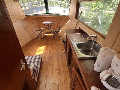 Hébergement insolite en bateau à Auvergne, intérieur en bois chaleureux et lumineux.