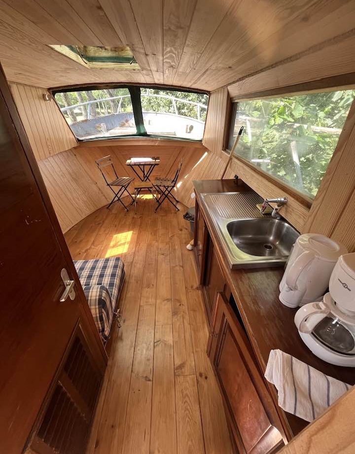 Hébergement insolite en bateau à Auvergne, intérieur en bois chaleureux et lumineux.