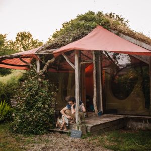 Hébergement insolite en Bretagne : cabane en bois avec toit végétal et terrasse accueillante.