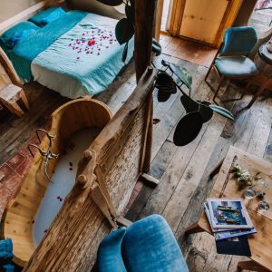Hébergement insolite en Bretagne : chambre avec baignoire en bois et décor floral.