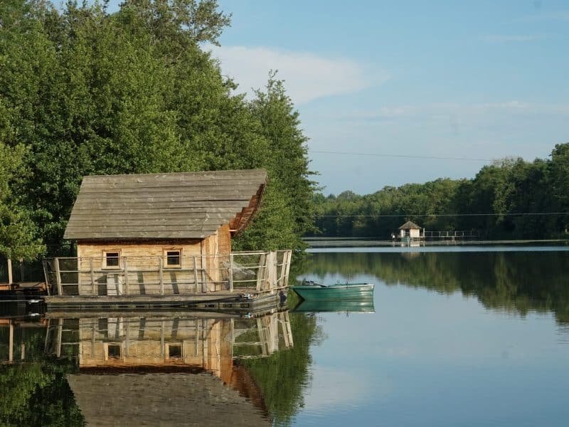 Cabane flottante au bord dun lac, entourée de verdure et de calme.