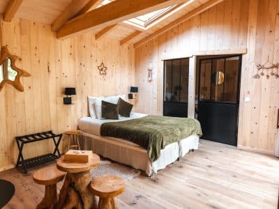 Chalet en bois chaleureux avec lit douillet et décor naturel dans les Hauts-de-France.