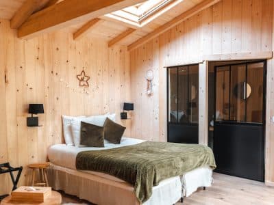 Chalet en bois chaleureux avec lit douillet et lumière naturelle. Parfait pour un séjour unique.