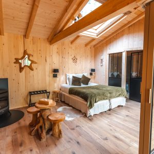 Cabane en bois chaleureuse avec un lit douillet et un poêle à bois.