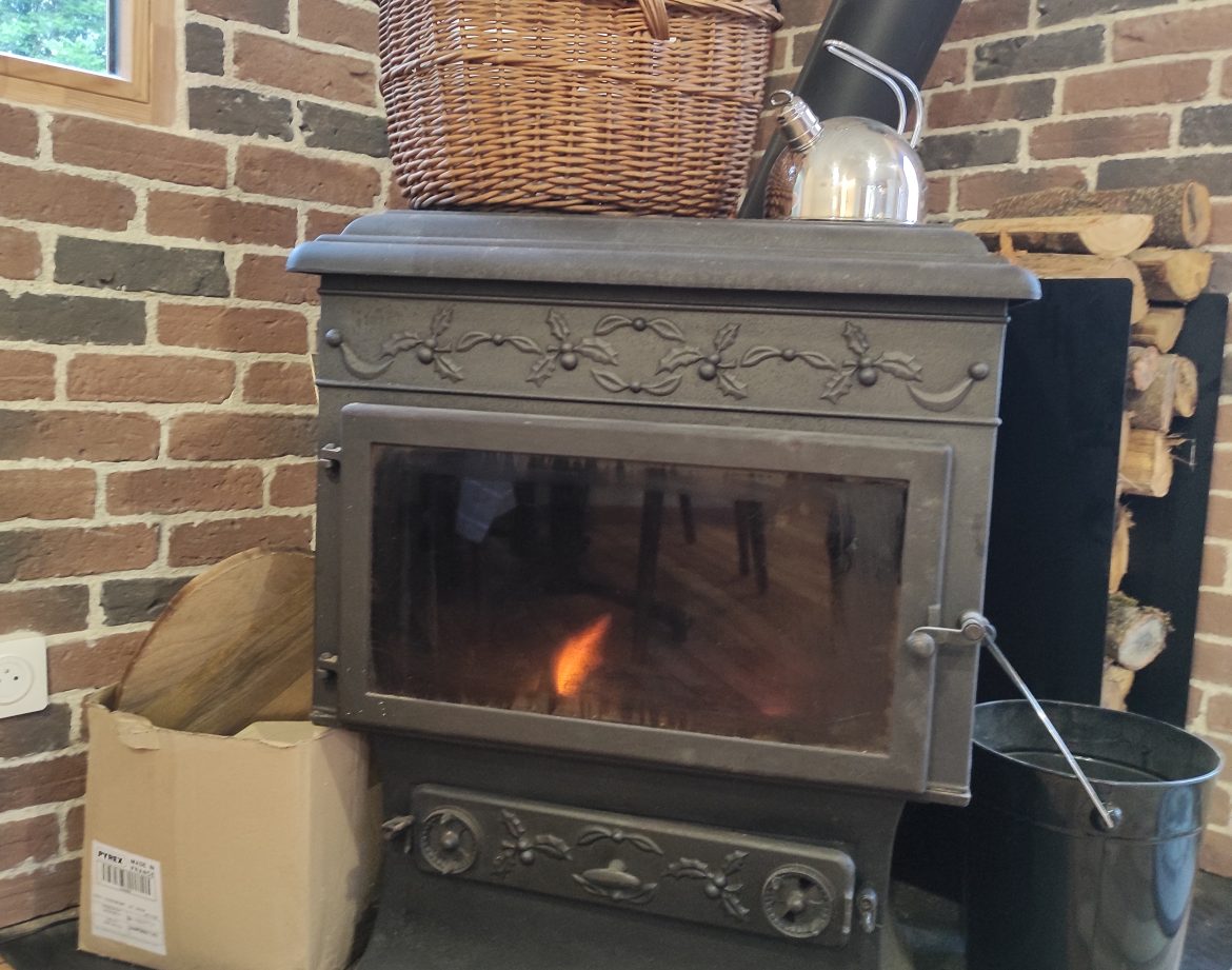Hébergement insolite à Limousin : poêle à bois vintage avec panier en osier.