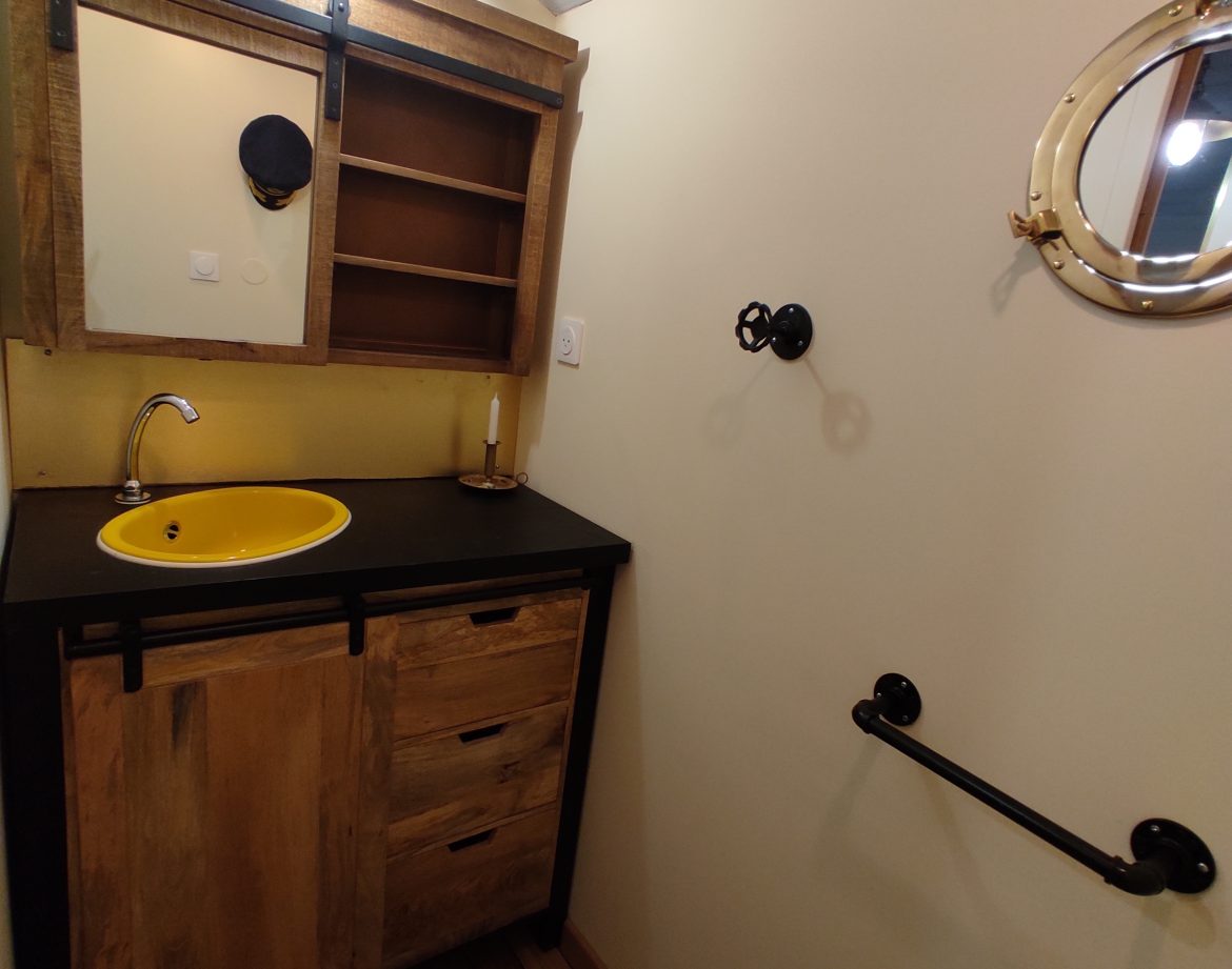 Salle de bain dun hébergement insolite en Limousin avec un lavabo jaune vif.