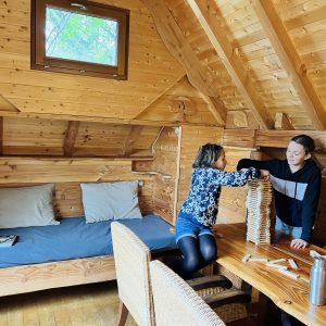 Chalet en bois chaleureux en Auvergne-Rhône-Alpes, avec un coin salon et jeux.