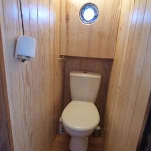 Toilettes en bois dans un hébergement insolite en Auvergne, ambiance chaleureuse.
