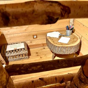 Cabane en bois avec un bureau en rondin et des fournitures créatives.