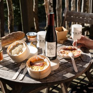 Hébergement insolite en Auvergne-Rhône-Alpes avec repas local sur une table en bois.