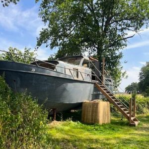 Hébergement insolite en bateau à Auvergne, perché sur pilotis avec un accès en escaliers.