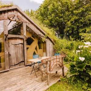 Hébergement insolite en Bretagne : cabane en bois avec grandes fenêtres et verdure environnante.