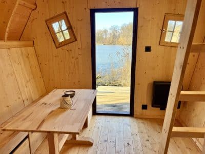 Cabane en bois avec vue sur leau, intérieur chaleureux et lumineux.
