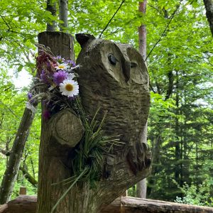Hébergement insolite en Auvergne-Rhône-Alpes, avec une sculpture de hibou ornée de fleurs.