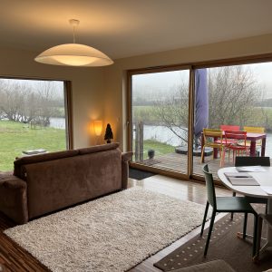 Hébergement insolite en Bourgogne : chalet moderne avec vue sur la rivière et mobilier coloré.