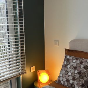 Chambre cosy dans un hébergement insolite en Bourgogne, avec lumière douce et décor moderne.