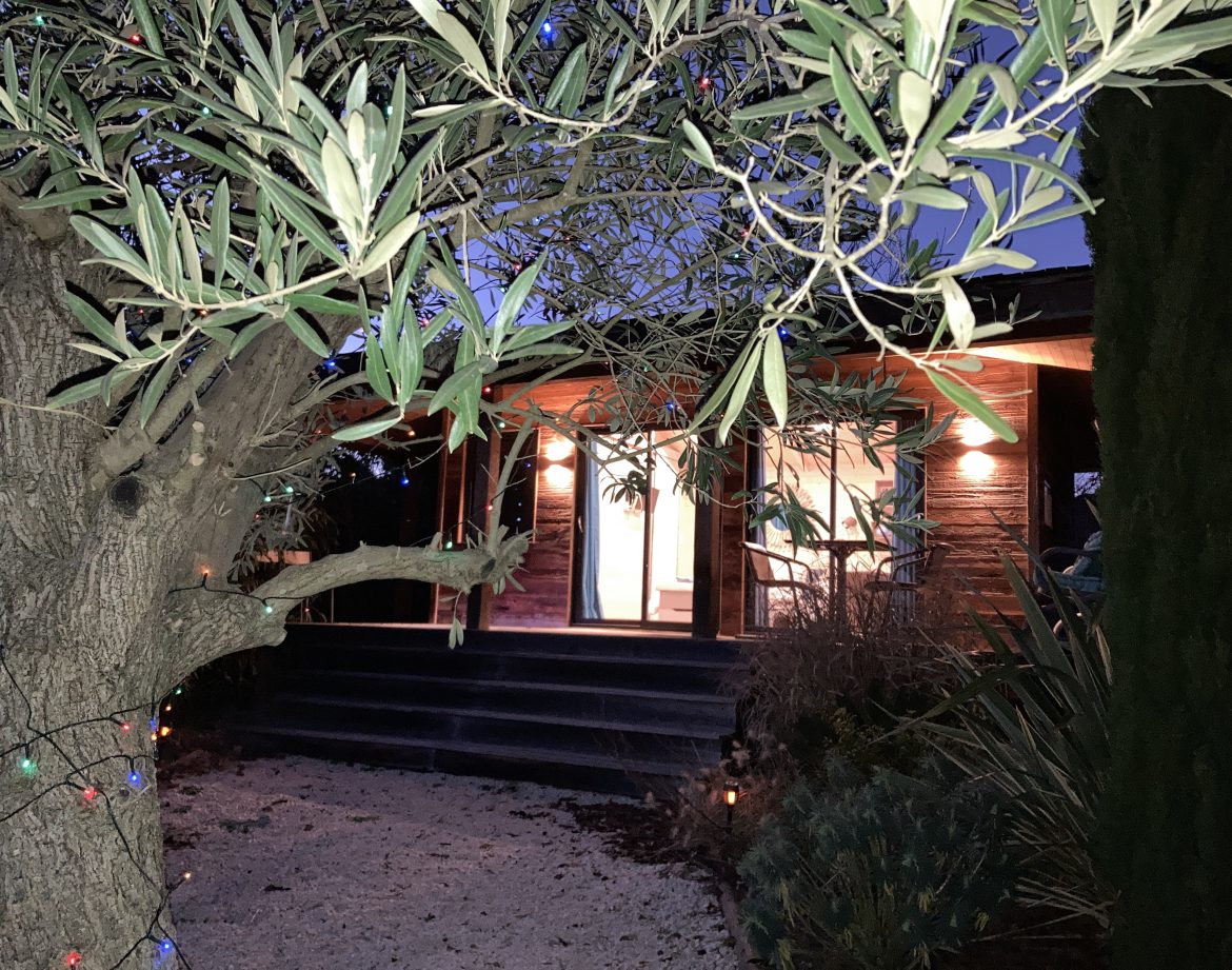 Cabane en bois au Languedoc-Roussillon, illuminée par des guirlandes.