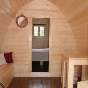 Intérieur dune cabane en bois, avec murs en pin et mobilier simple et chaleureux.