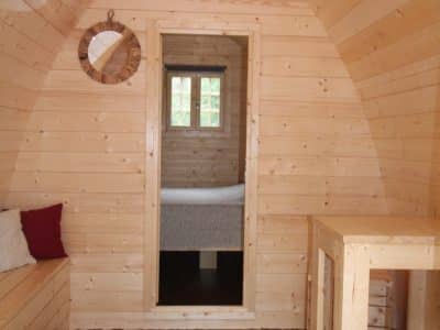 Intérieur dune cabane en bois, avec murs en pin et mobilier simple et chaleureux.