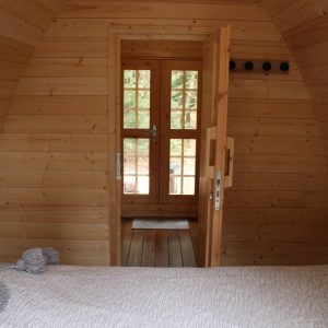 Cabane en bois avec porte vitrée, offrant une ambiance chaleureuse et naturelle.