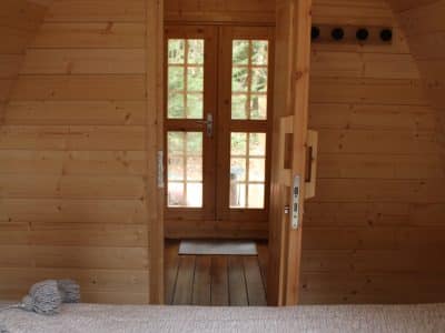 Cabane en bois avec porte vitrée, offrant une ambiance chaleureuse et naturelle.