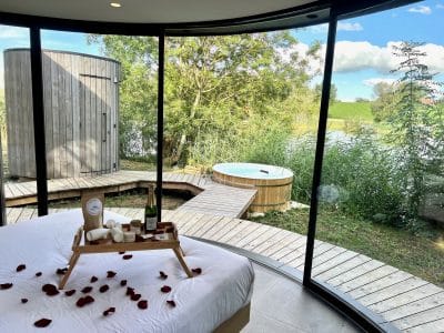 Hébergement insolite en bulle avec vue sur la nature et jacuzzi extérieur.