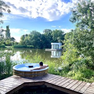 Hébergement insolite en Auvergne-Rhône-Alpes avec jacuzzi en bois au bord dun lac.
