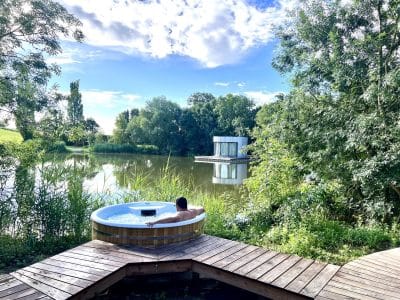 Hébergement insolite en Auvergne-Rhône-Alpes avec jacuzzi en bois au bord dun lac.