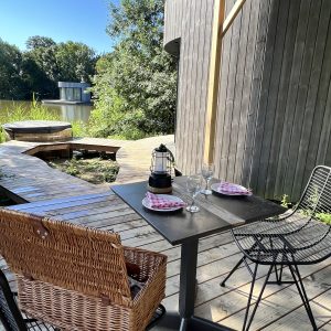Hébergement insolite en Auvergne-Rhône-Alpes avec terrasse en bois et vue sur la nature.
