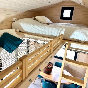 Chalet en bois avec mezzanine, lit douillet et décoration chaleureuse.