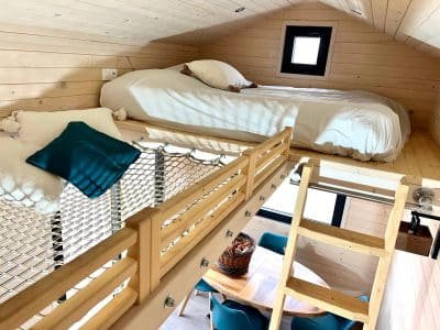 Chalet en bois avec mezzanine, lit douillet et décoration chaleureuse.