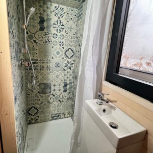 Douche moderne dans un hébergement insolite en Auvergne-Rhône-Alpes, carrelage coloré.