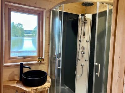 Douche moderne en bois dans un hébergement insolite au bord dun lac en Auvergne-Rhône-Alpes.