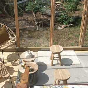 Hébergement insolite en serre avec télescope et fauteuils confortables.