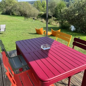 Hébergement insolite en Bourgogne avec terrasse colorée et vue sur la nature verdoyante.